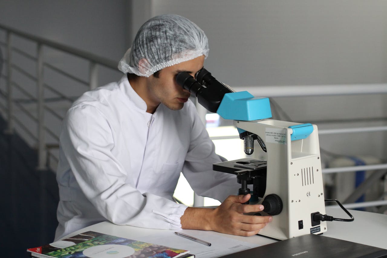 about-us Scientist in a lab coat using a microscope to conduct research, focusing on healthcare improvements.