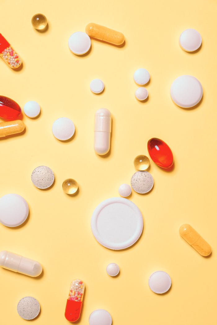 services-04 Colorful assortment of pills and capsules on a vibrant yellow background.